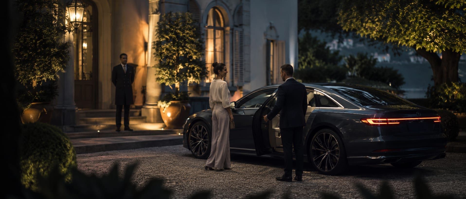 A luxury car handed over outside a private residence in soft evening light.