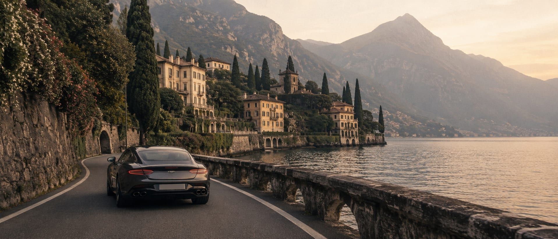 A corniche road tracing the shoreline of Lake Como under clear light.